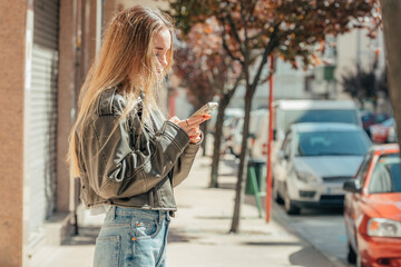 blonde girl on the street outdoors with mobile phone