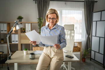 mature woman read contract document paper at office happy smile