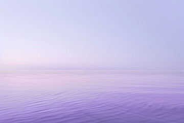 A calm, serene ocean with a purple sky in the background. The water is still and the sky is a soft,...