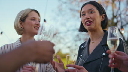 Diverse group drinking champagne park closeup. Friends celebrating party in bar