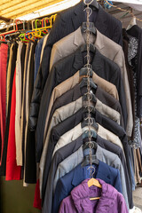 Modern second hand male jackets sold on market outside - 776419783