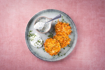 Traditional parsnip potato pancakes with chives and quark dip served as a top view on a Nordic...