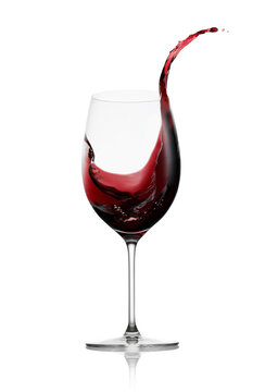 Red wine in a glass with splash isolated on white background