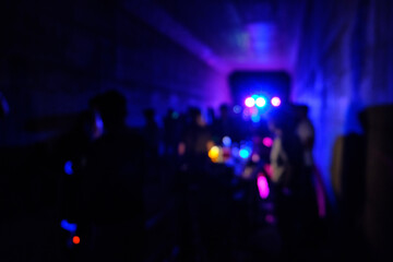 Underground disco party. Flashing lights and defocused silhouettes of people on a dance party