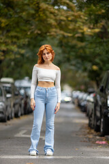 portrait of young redhead woman standing in the street - 776432135