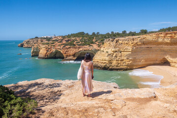 Tourist admiring cliffs near Benagil in Algarve region, Portugal