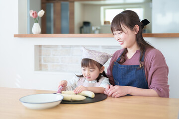 Obraz na płótnie Canvas お母さんと一緒に料理を手伝う女の子