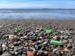 Seaglass in different colors among the pebbles on a beach along the Bay of Fundy, New Brunswick,...