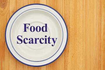 Food scarcity on empty plate on a wood table - 776486993