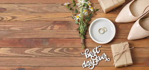 Tray with wedding rings, bride accessories and text BEST DAY EVER on wooden background
