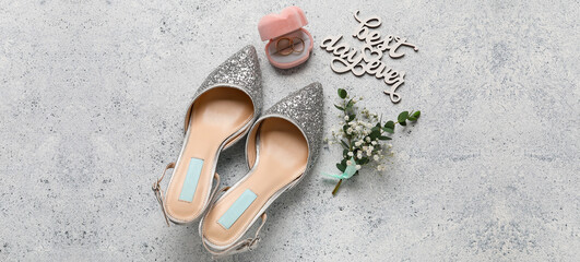 Box with wedding rings, bride shoes, boutonniere and text BEST DAY EVER on grunge background