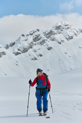 Fototapeta na wymiar A Female Mountaineer Ascends the Alps with Backcountry Gear