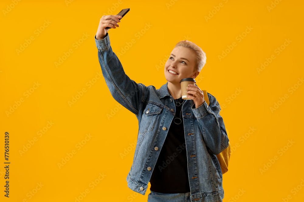 Sticker female student with cup of coffee and mobile phone taking selfie on yellow background