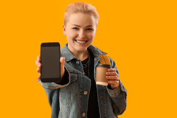 Female student with cup of coffee and mobile phone on yellow background