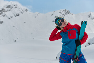 A professional woman skier rejoices after successfully climbing the snowy peaks of the Alps - 776511712