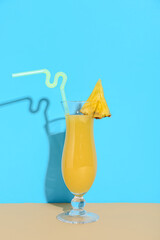Glass of tasty pineapple juice on color background