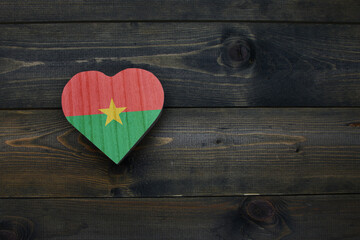 wooden heart with national flag of burkina faso on the wooden background.