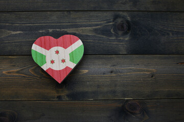 wooden heart with national flag of burundi on the wooden background.
