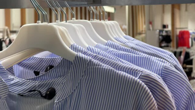 Effortless Summer Style: Crisp Cotton Striped Blouses Hang Invitingly on Display at Women's Boutique. Close-up shot