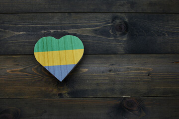 wooden heart with national flag of gabon on the wooden background.