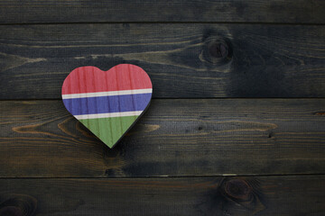 wooden heart with national flag of gambia on the wooden background.