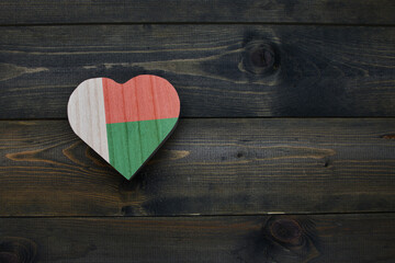 wooden heart with national flag of madagascar on the wooden background.