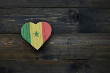 wooden heart with national flag of senegal on the wooden background.