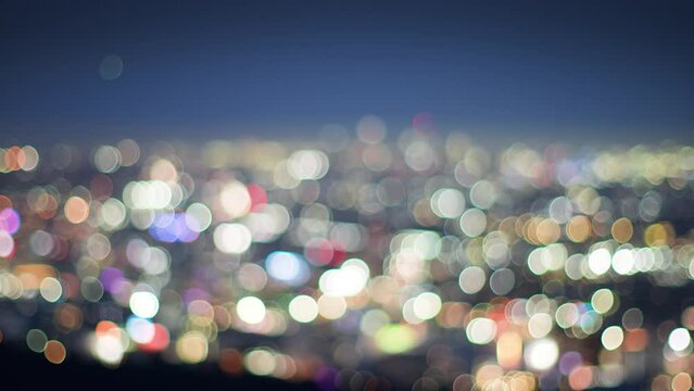 City of Los Angeles cityscape at night. Cinematic transition from defocused bokeh blur to illuminated downtown LA skyline.