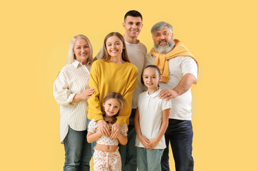 Big family hugging on yellow background - obrazy, fototapety, plakaty