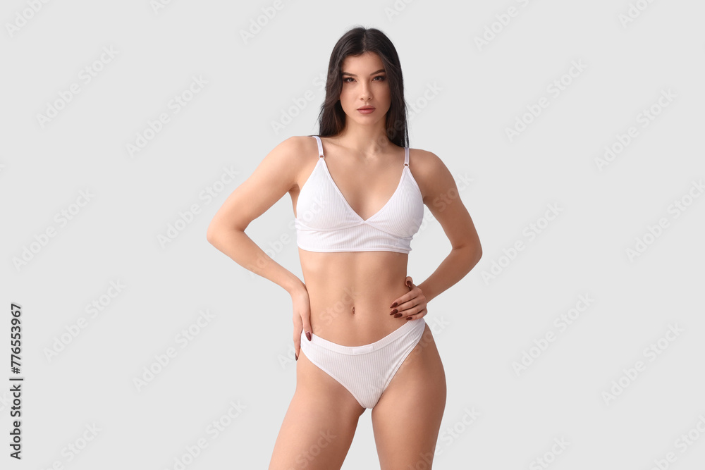 Wall mural pretty young woman in white underwear on blue background