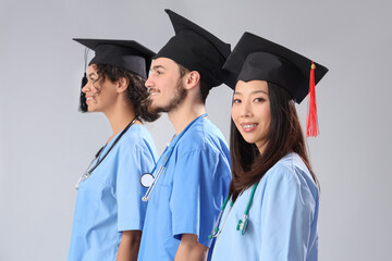 Proud medical graduate students standing in line on white background