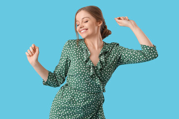 Beautiful young happy woman dancing on blue background