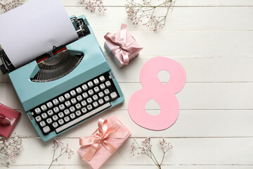 Festive composition with typewriter and postcard in shape of number eight on white wooden table