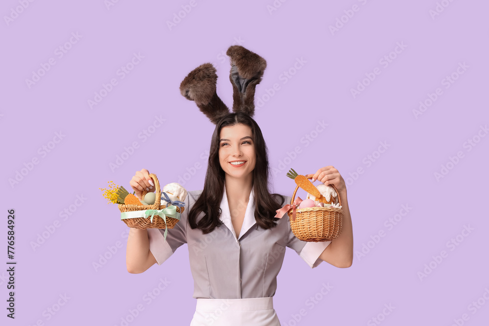 Sticker Happy female chambermaid in bunny ears with Easter baskets on purple background