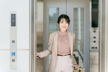 エレベーターに乗る女性・ビジネスウーマン（商業施設・駅・ビル・出張）  © buritora
