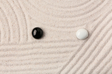 Stones on sand with lines in Japanese rock garden, top view. Zen concept