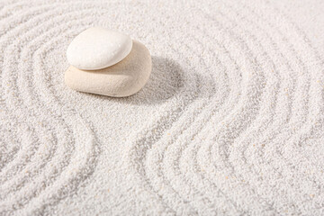 Fototapeta na wymiar Stones on sand with lines in Japanese rock garden. Zen concept