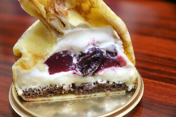 チェリーとベリーソースとクリームとチョコのクレープ包みのケーキの断面