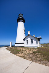 Yaquina Head Lighthouse against blue sky, along Pacific coast in Oregon, USA.