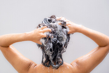Beautiful woman's hand She was washing her hair and nourishing her scalp. Shampoo and conditioner	
