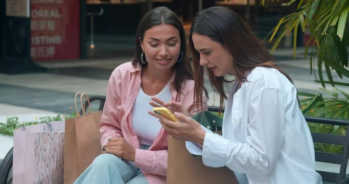 On bench best friends share stories use phones reflecting women's friendship. Women's friendship highlighted genuine smiles joyful interaction Women's friendship essence camaraderie elegance.
