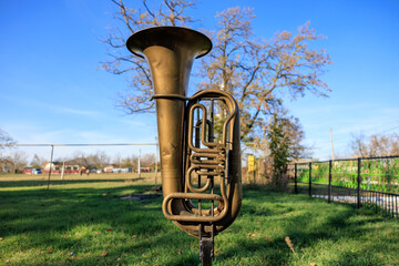 A brass instrument is sitting on a grassy field