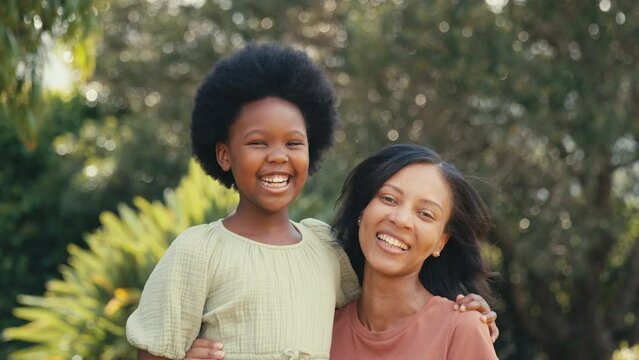 Close up of smiling loving mother cuddling laughing daughter outdoors in countryside enjoying nature- shot in slow motion