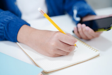 Asian teenage using mobile application in digital smartphone technology for learning.