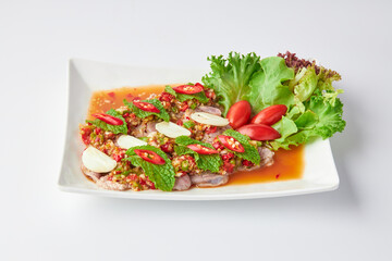 Sliced beef shank salad, spicy and sour flavor, decorated with sliced chili, garlic, salad leaves...