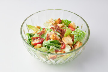 Classic Caesar salad with bacon mixed with green salad, Croutons (Crispy Bread), Crispy Bacon and Tomatoes , topped with Parmesan cheese on bowl isolated on white background. healthy food.