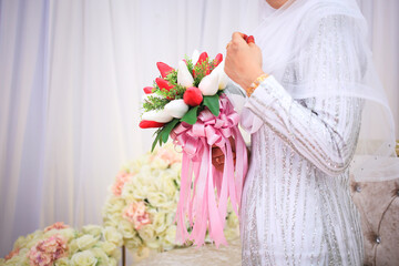Beautiful bouquet of different colors in the hands of the bride in a white dress. Bride holding her...