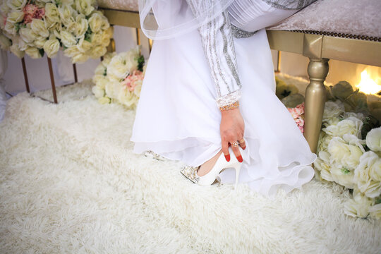 A bride wearing shoes on wedding day. Beautiful bride is getting ready for her wedding. Close up image.