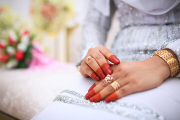 Close-up of wedding details. The bride's wedding ring on the finger. Malay Wedding day.