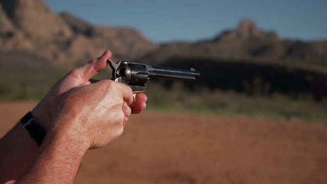 A man shooting a classic revolver gun